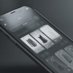 Smartphone displaying a dark-mode fashion shopping app interface with clothing product cards and minimalist UI design.